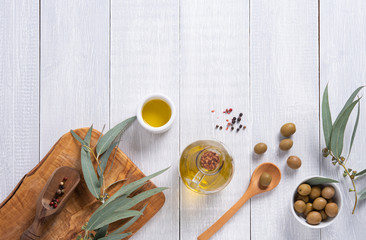 ripe natural eco friendly olives with olive oil in a bottle on a white wooden background