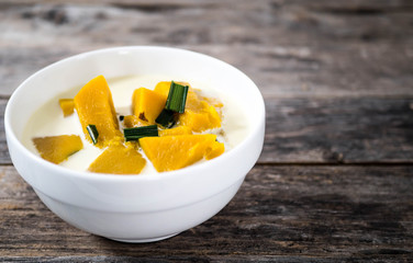 Pumpkin in coconut milk on a wooden table Sweet food in Thailand