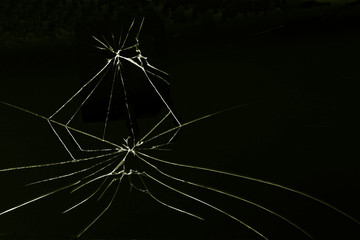 a crack on a broken glass mirror , on a black background in the form of an abstraction as a drawing in the form of an image