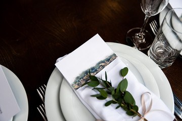 White napkin with eucalyptus and guest card on it