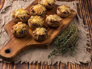 Obraz na płótnie Canvas baked mushrooms with vegetables and cheese on a wooden board.