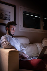 boy watching the computer in the evening and smile