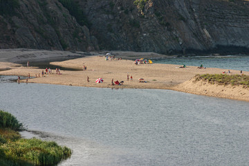 The mouth of the Veleka River in Sinemorets. The beach divides the fresh water of the river from the salt water of the Black Sea. At the end of the summer day there are still vacationers on the beach.