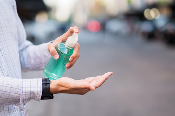 man hand using wash hand sanitizer gel dispenser, against Novel coronavirus or Corona Virus Disease (Covid-19) at public outdoor. Antiseptic, Hygiene and Healthcare concept