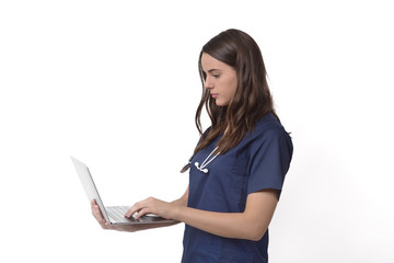 Naklejka premium Young female doctor with stethoscope over neck working on laptop, isolated on white