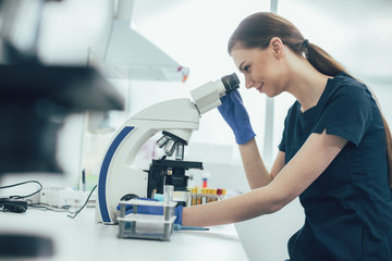 Gladsome specialist with modern microscope stock photo