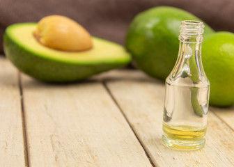Raw avocado, oil and lime on a wooden background side view