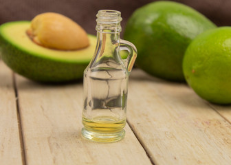 Raw avocado, oil and lime on a wooden background side view