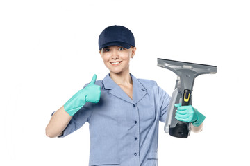 Young white woman in a maid uniform and a baseball cap holds a steamer in her hands and smiles isolated on a white background.