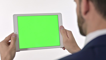 Rear View of Businessman watching Video on Tablet with Chroma Screen, White Background