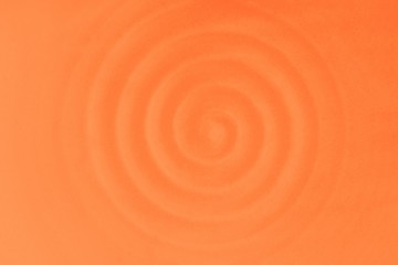 Ceramic dish, circular vibrations. Soft orange rippled waves. Warm background