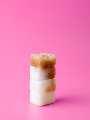 column of sugar cubes isolated on pink