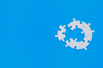 Private pieces per white unfinished jigsaw puzzle on a blue background.