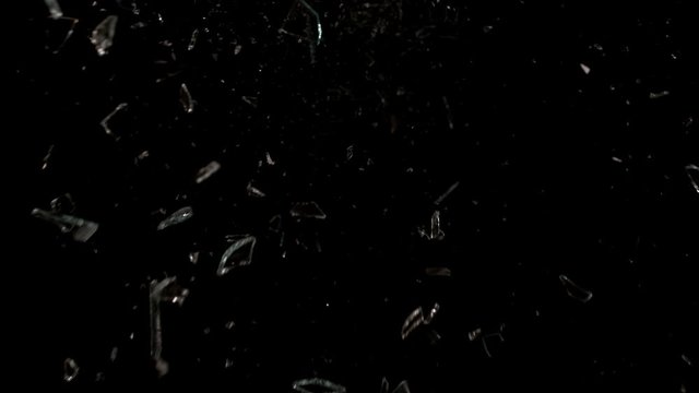 Glass breaking in slow motion on black background