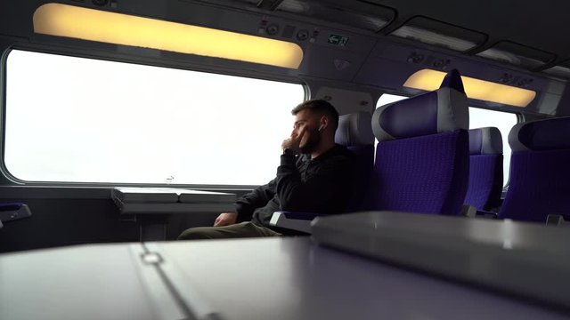 Jeune homme regarde par la vitre pendant voyage en train