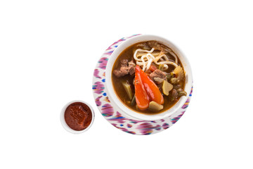 Uzbek noodle soup Lagman with noodles and lamb isolated on white background