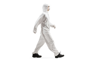 Man wearing a protective suit and mask and walking
