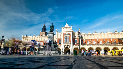 Fototapeta premium Krakow, Poland, view on the the old town market square and Cloth Hall with blurred pedestrians