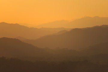 Orange sky over hazy mountains around Luang Prabang, Laos. View from the top of Mount Phou Si.