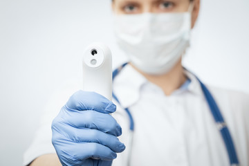 Doctor pointing infrared thermometer gun to check body temperature epidemic virus outbreak concept