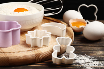 Fototapeta na wymiar Baking utensils and ingredients. rolling pin, cookie mold,. cupcake cases and sugar sprinkling on a wooden background. Easter concept.