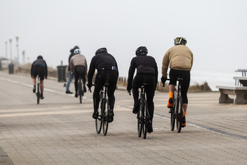 bicycle riders on the dunes in Netherlands on a stormy day