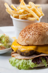 cheeseburger with french fries on wooden table