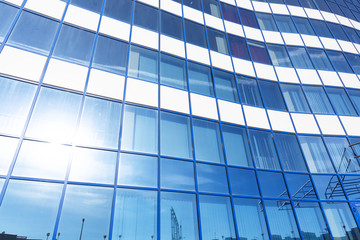 Fototapeta premium Reflection of the sun and city building silhouettes in the glass of an office building