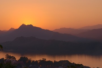 Obraz premium Sunset over the Mekong river and hazy mountains. View from Mount Phou Si, in Luang Prabang, Laos.