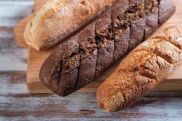 three baguettes of rye and wheat flour on a wooden Board