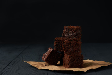 Stack of a brownie pieces on a grey table with dark background.