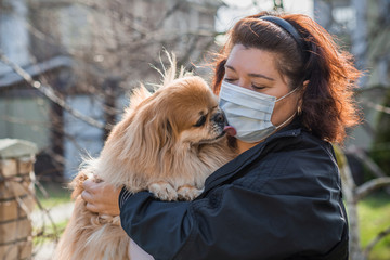 Virus concept. Mature woman in mask with his dog, risk for health and problem