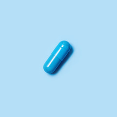 One blue capsule. Pills for men's health and sexual energy on an isolated background. Concept of erection, potency. Treatment of male infertility and impotence. Copy space