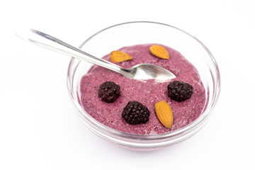 Smoothie made of blackberries in the bowl with almonds