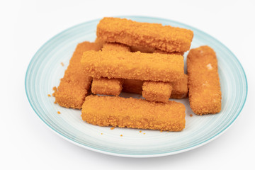 Fototapeta na wymiar Fried fish sticks on the plate above white background