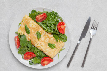 Omelette with spinach, arugula and cherry tomatoes. Healthy delicious Breakfast