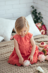 Girl playing with flowers on the bed