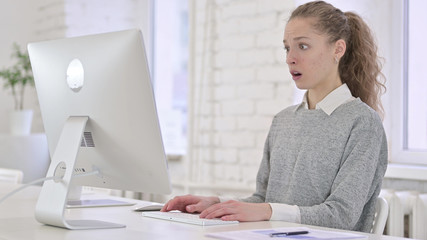 Young Latin Woman having Failure on Desktop in Modern Office