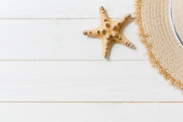 Straw hat and starfish On a white wooden background. top view summer holiday concept with copy space