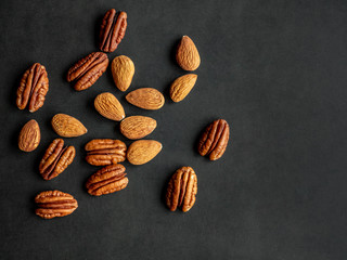 .Pecan und almond nuts on black wooden board, high resolution photo