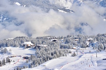 Ski resort in winter with snowy mountains and clouds 