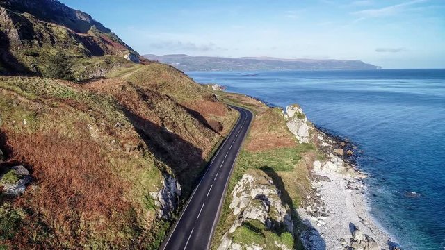 Northern Ireland, UK, Atlantic coast with cliffs. Causeway Coastal Route a.k.a Antrim Coast Road a.k.a. One of the most scenic coastal roads in Europe. Aerial 4K video. Winter, sunrise light.