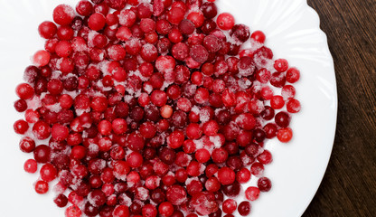 Fresh-frozen cranberries or red currants on a white plate. Healthy diet. Top view