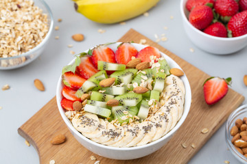 Smoothie bowl with banana, strawberry, almond, Chia seeds, kiwi and granola. Delicious healthy Breakfast