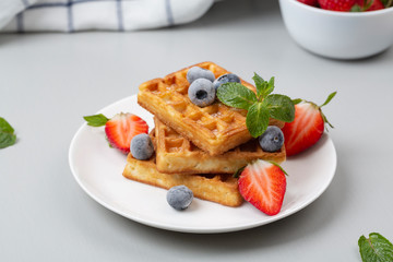 Belgian waffles. Tasty waffles with strawberries and blueberries for Breakfast.