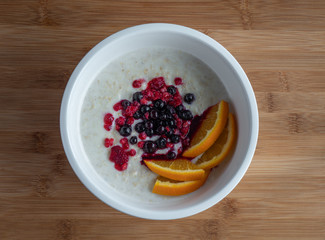 Oatmeal with fruit on wooden table, high resolution photo