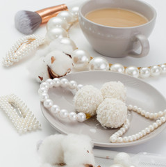 Jewelry for the bride, pearls, makeup brushes, delicate colors, candy and coffee, on a white background. Conceptual photography for weddings, preparation and morning of the bride.