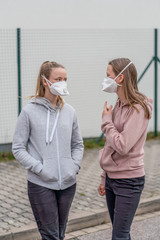 2 Jugendliche Mädchen Menschen mit Atemmaske auf der Straße in Deutschland wegen Coronavirus