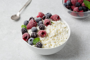 Cottage cheese with berry blueberry, raspberry and blackberry, selective focus