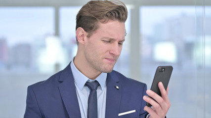 Portrait of Cheerful Young Businessman Celebrating on Smartphone